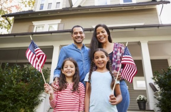 family-with-daughters-holding-american-flags