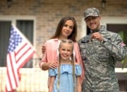 Military family outside of new home with keys