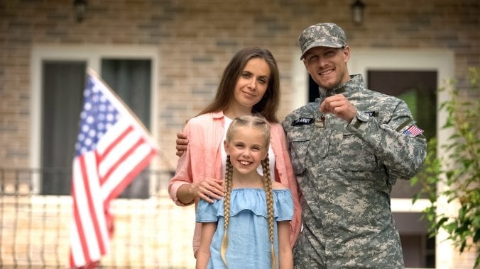 Military family outside of new home with keys